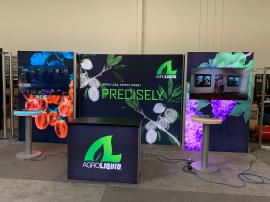 RENTAL: RE-2138 Inline Design with (3) Single-Sided Lightboxes, (2) Large Monitor Mounts, 60” Monitors, RE-1567 Backlit Reception Counter, (2) RE-711 Charging Station Tables, SEG Backlit Fabric Graphics, and Vinyl Applied Graphics